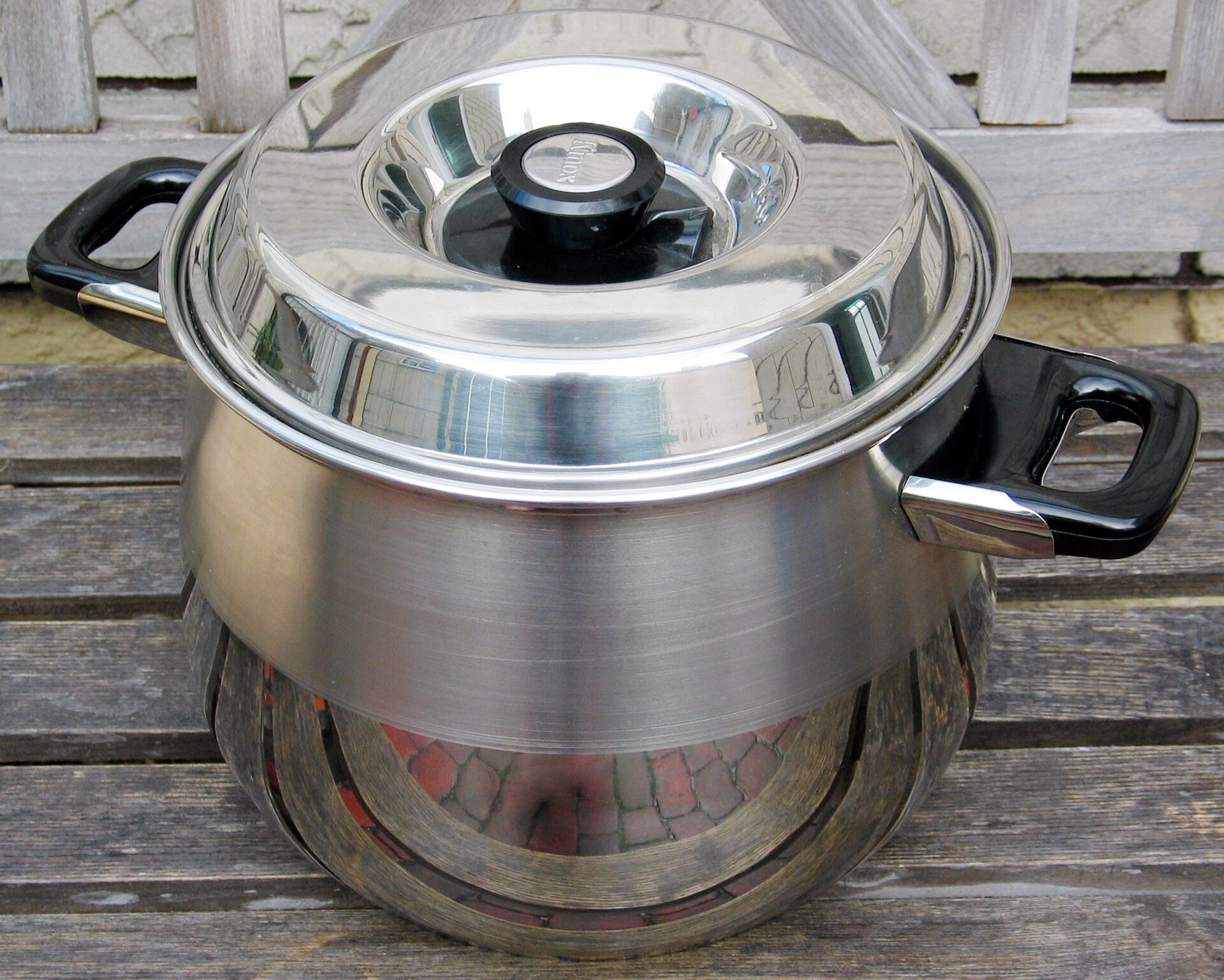 Stainless steel saucepans and a stockpot with lids on a clean kitchen counter