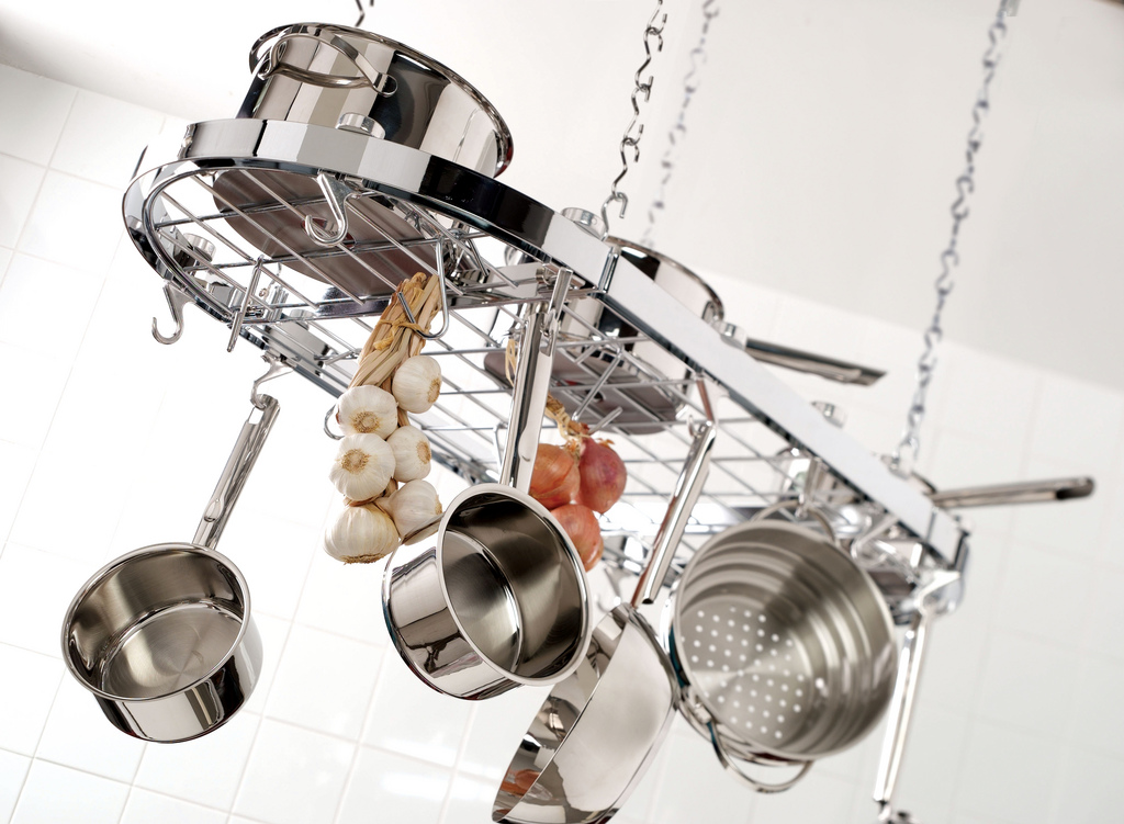 Stainless steel saucepans and a stockpot with lids on a clean kitchen counter