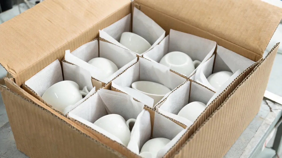 Fragile ceramic items wrapped with dividers in an export carton - illustrative